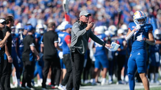 Kansas head coach Lance Leipold speaking to a player on the sideline.